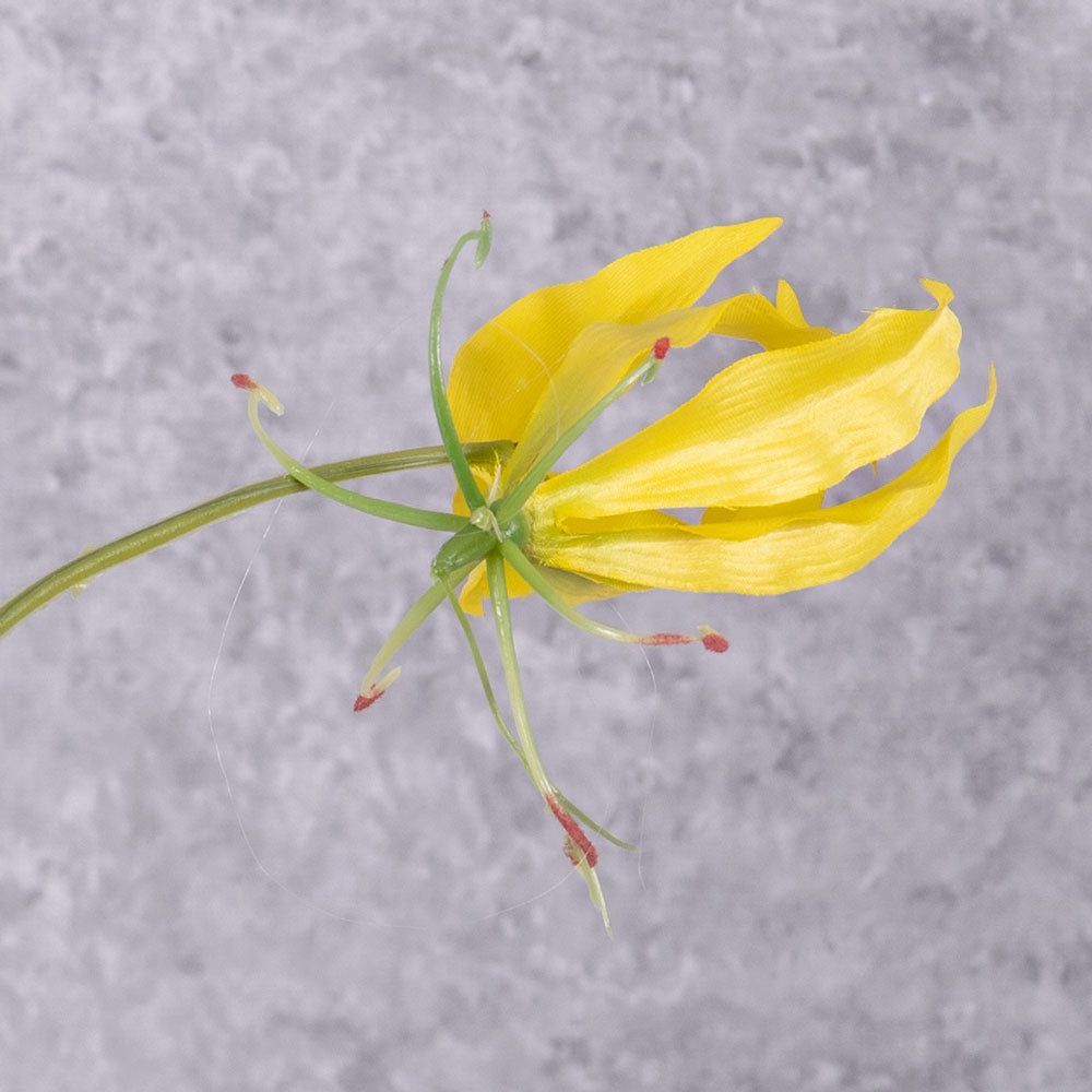A close up of a faux gloriosa with a yellow flower