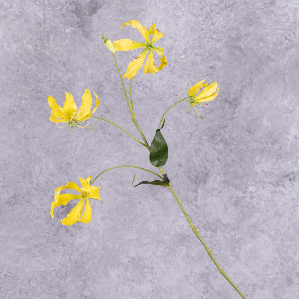 A faux gloriosa spray with 4 yellow flowers, and 1 bud