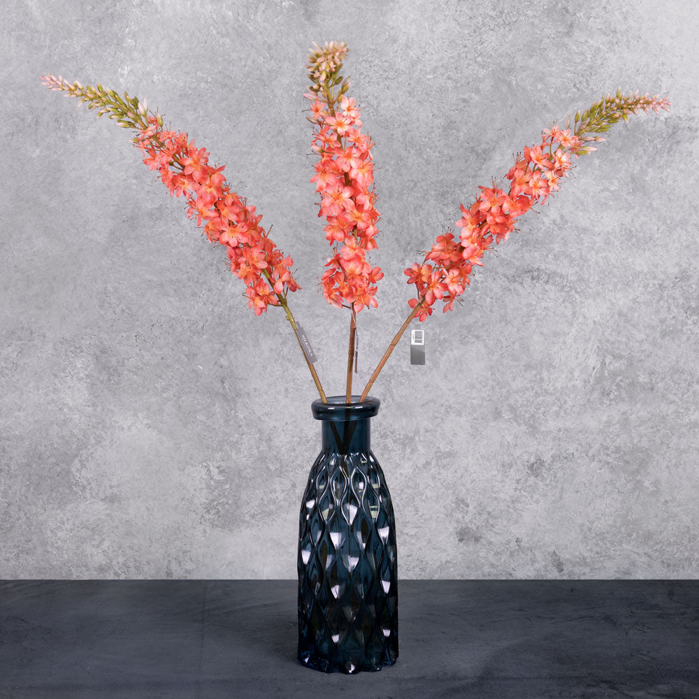 A close up shot of a faux foxtail lily with warm salmon flowers showing the top detail