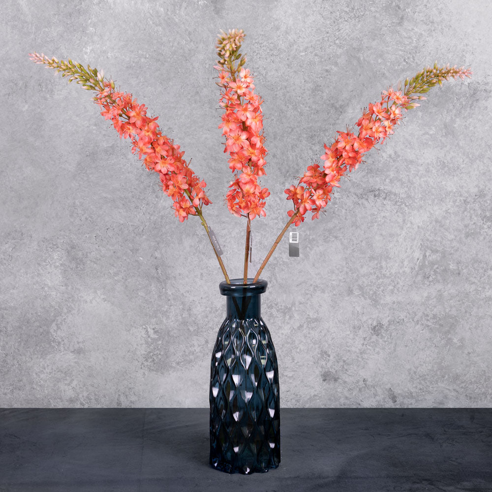 A close up shot of a faux foxtail lily with warm salmon flowers