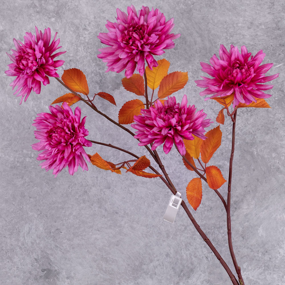 A close up of some bright pink, faux chrysanthemum flowers with orange-red leaves