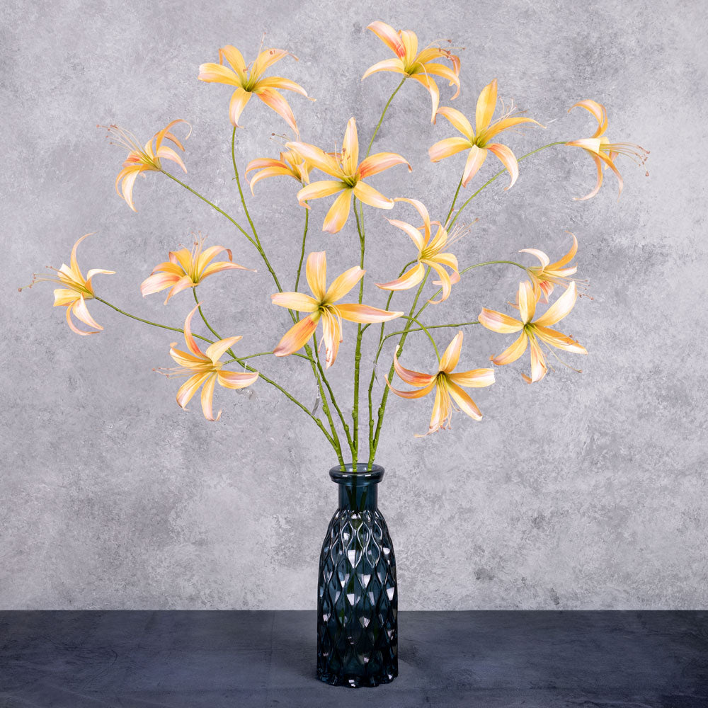 A tall. faux lily spray with peach flowers