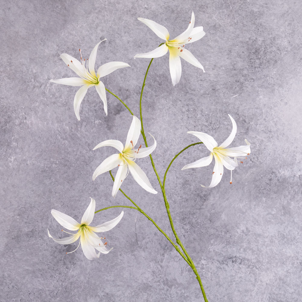A tall. faux lily spray with white-cream flowers