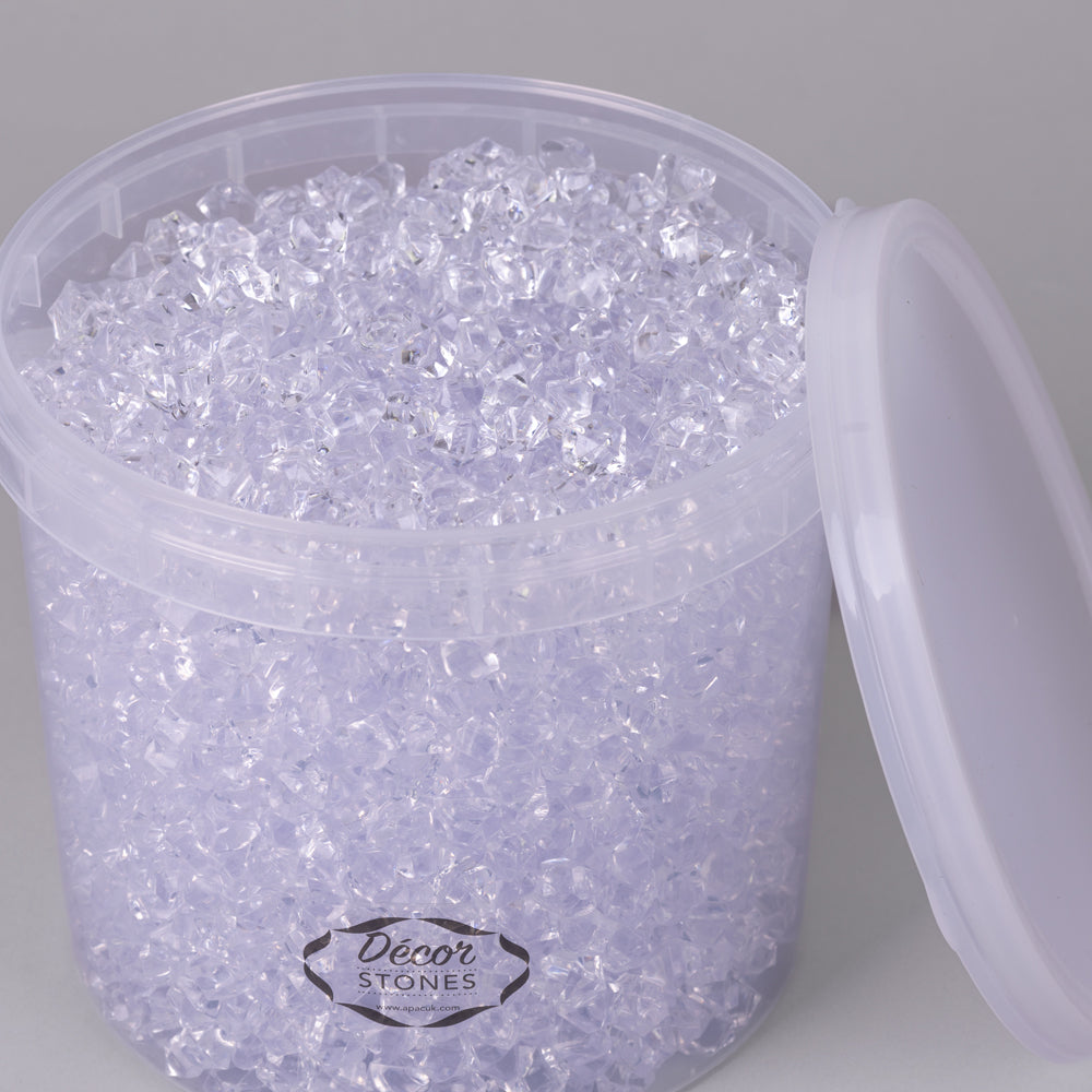 An open bucket of small, clear acrylic stones, in a plastic tub